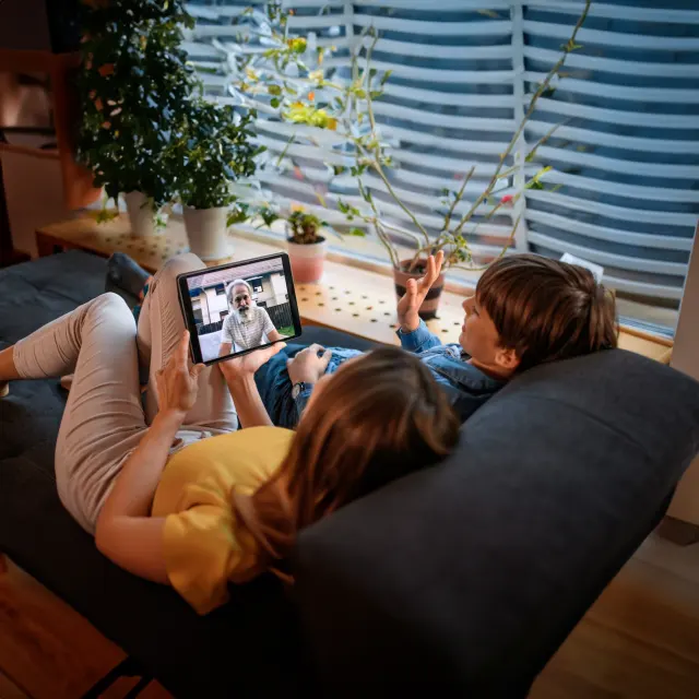 Mão em video chamada com filho